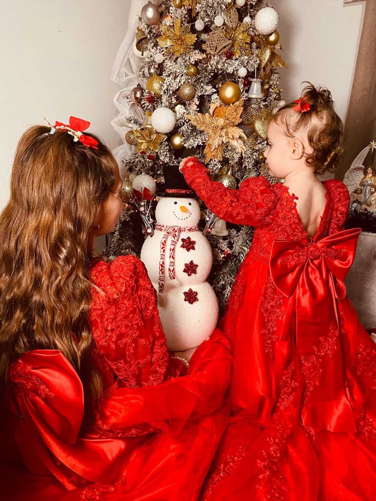 There’s nothing sweeter than the bond between sisters. Dressed in matching holiday red and mesmerized by the tree, these two are making memories that will last a lifetime.🎄❤️ @marina_marisa12